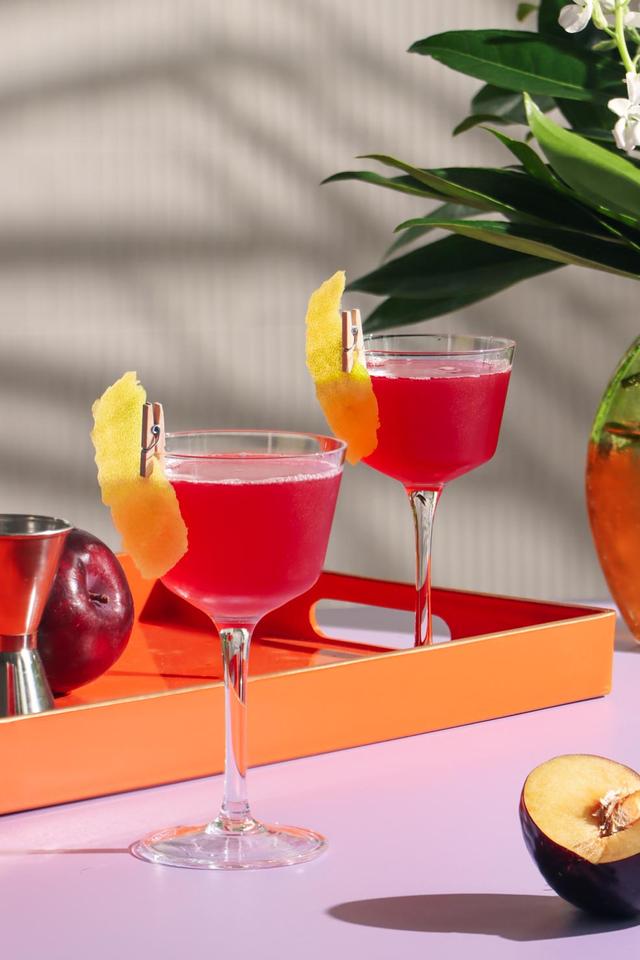 a refreshing Summer Plum Cosmo on a sun drenched backdrop